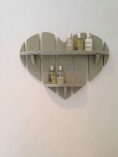 a heart shaped shelf with some bottles on it and soaps in the bottom corner