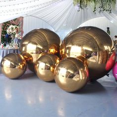 several shiny balls sitting on top of a white floor