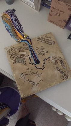 a decorated graduation cap sitting on top of a table next to books and other items