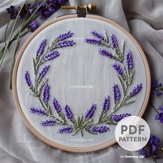 the embroidery pattern has lavender flowers on it and is ready to be made into a wreath