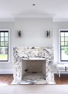 a living room with a fireplace and two windows