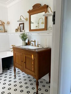 a bathroom with a sink, mirror and bathtub in it's center area