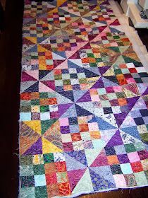 a multicolored quilt is laying on the floor