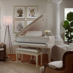 a white piano in a living room next to a couch