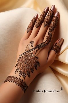 a woman's hand with henna tattoos on it and her hands holding the fabric