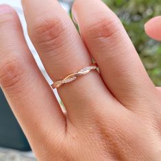 a woman's hand with a gold ring on top of her finger and a diamond in the middle