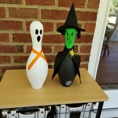 two halloween decorations sitting on top of a table