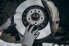 a person working on a vehicle's brake assembly