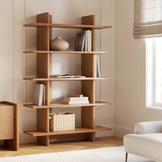 a living room with a book shelf in the corner and a white chair next to it