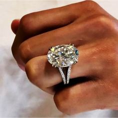 a close up of a person's hand holding a diamond ring