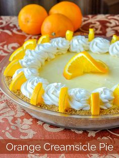 there is a cake with oranges on it and white icing around the edges