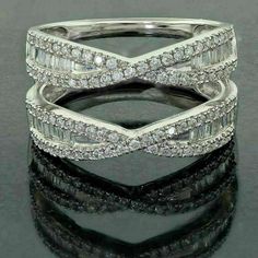 two bands of white gold with diamonds in them on a reflective surface, one band is set into the shape of an x