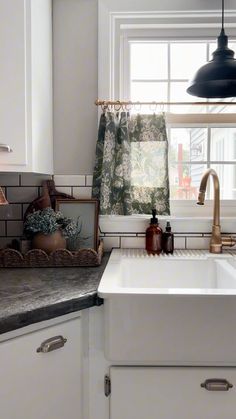 a white kitchen sink sitting under a window