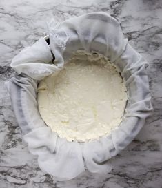 a white cake sitting on top of a marble counter next to a cloth wrapped around it