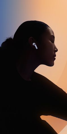 a woman with ear buds on her ears is looking at something in the distance behind her