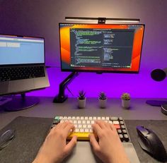 a person typing on a keyboard in front of a computer monitor