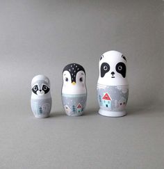 three small ceramic animals sitting next to each other on a gray surface with white background