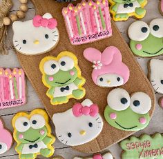 some hello kitty cookies are on a table with other decorated cookies in the shape of animals