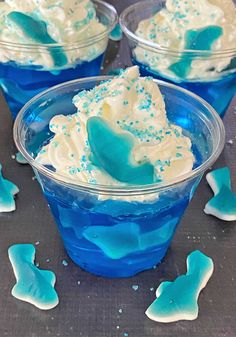 blue and white desserts in plastic cups with sprinkles on the side