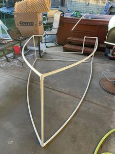 a large metal object sitting on top of a cement floor next to a chair and other furniture