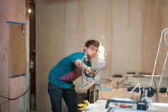 a man is working on something in his workshop with a drill and some other tools