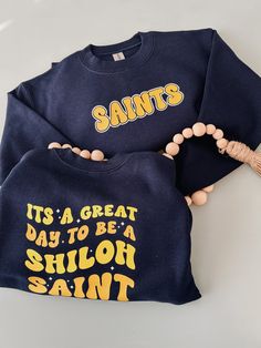 This retro front and back crewneck is perfect for all Saints from pre-k through mom and dad! It's always a great day to be a Shiloh Saint WELCOME TO MADISONMAKES CO. If you are looking for cute, comfortable, well-made tees, you're in the right place! My goal here at MadisonMakes Co. is to help you celebrate your personality and your favorite things through apparel. If you have any questions, concerns, or comments about these products, feel free reach out. I will respond as quickly as I can! Don't see something you love? I love to create custom designs! Send me a message for a free design proof, and help me bring your vision to life. PRODUCT DETAILS  All t-shirts and sweatshirts are unisex sizing. Please make sure you select the right color and size, as well as include any personalization y Blue School Spirit Sweatshirt For School, Blue School Spirit Sweatshirt, School Spirit Pre-shrunk Crew Neck Sweatshirt, Team Spirit Letter Print Sweatshirt For School, School Team Spirit Sweatshirt With Letter Print, School Crew Neck Sweatshirt With Team Name, School Fan Apparel Sweatshirt With Letter Print, Pre-shrunk Crew Neck Sweatshirt School Spirit, Crew Neck Sweatshirt With Screen Print For School