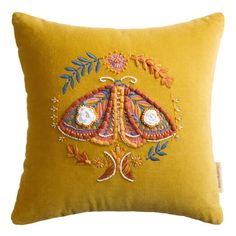 a yellow pillow with embroidered designs on it