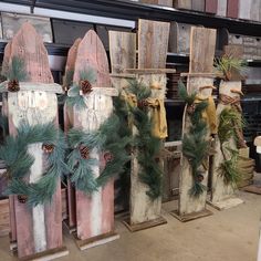 three wooden sleds decorated with pine cones and greenery