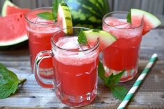 three glasses filled with watermelon and limeade on top of a wooden table