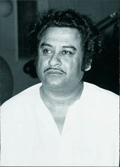 a black and white photo of a man with curly hair wearing a collared shirt