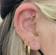 a close up of a person's ear with three different types of piercings