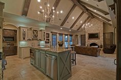 a large kitchen with an island in the middle and lots of lights hanging from the ceiling