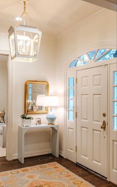 a white entryway with two doors and a rug on the floor next to it