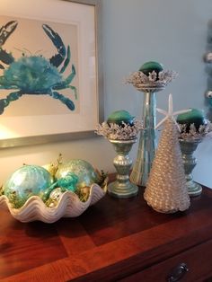 a table topped with vases filled with green and white ornaments on top of a wooden table