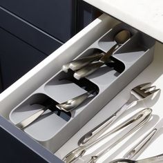 the utensils are organized in an open drawer