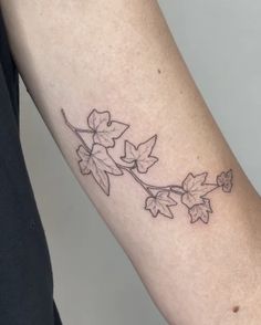 a woman's arm with a tattoo on it that has flowers growing out of it