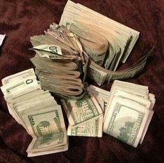 a pile of money sitting on top of a bed