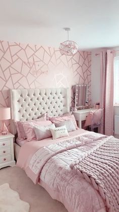 a bedroom decorated in pink and white with a large headboard on the side of the bed