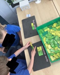 two children are playing with sticky notes on the table