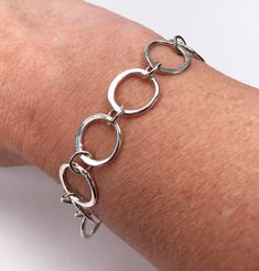 Scandinavian style forged silver bracelet. Circles symbolise love and completeness and this bracelet would make a lovely gift for a loved one, Mother's day or for a friend. The bracelet has a forged assymetric circle links which are lightly hammered and the light when it's being worn.  A lovely, contemporary bracelet which looks great on it's own or when worn with bangles too.   This bracelet is 20cm long and the silver circles approx. 1.5mm in diameter; this is a medium wrist size length. The b Handmade Sterling Silver Round Bracelet For Everyday, Handmade Round Sterling Silver Bracelet For Everyday, Modern Round Sterling Silver Bracelets, Modern Round Sterling Silver Bracelet For Anniversary, Modern Handmade Bracelets For Anniversary, Modern Round Sterling Silver Bracelet, Handmade Modern Sterling Silver Bracelets, Modern Handmade Sterling Silver Bracelets, Hand Forged Sterling Silver Bracelet As Gift