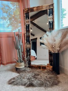 a large mirror sitting on top of a floor next to a vase filled with feathers