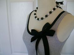 a mannequin wearing a black and white top with pearls on it's neck