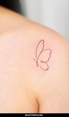 a small butterfly tattoo on the back of a woman's left shoulder is shown