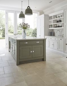 an image of a kitchen with white cabinets and gray island in front of the window