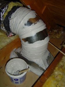 a large pipe is wrapped in plastic and sitting on the floor next to a bucket