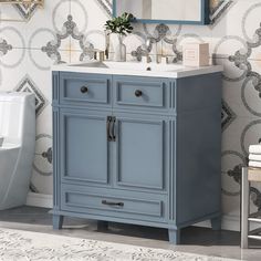 a bathroom vanity with a blue cabinet next to a white toilet and sink in front of a mirror