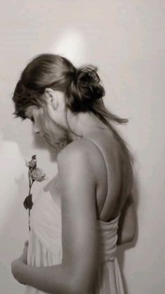 a black and white photo of a woman holding a rose