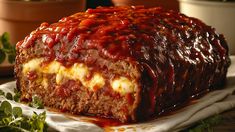 a meatloaf covered in sauce and cheese on top of a white napkin next to potted plants