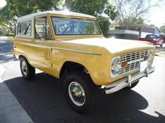 an old yellow truck is parked on the street