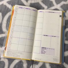 an open planner book sitting on top of a bed